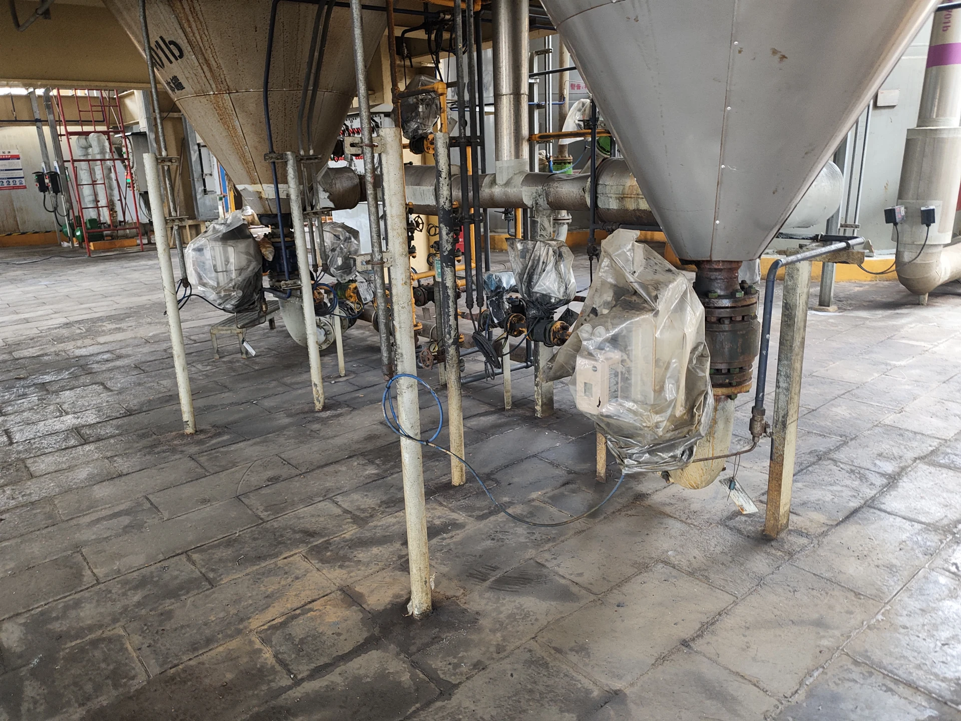 Valves beneath process hoppers in a polysilicon installation